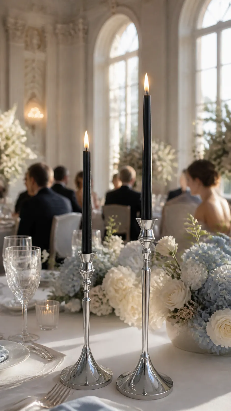 Paired candleholders for a reception table Two classic silver Glassy candleholders on a white floral table