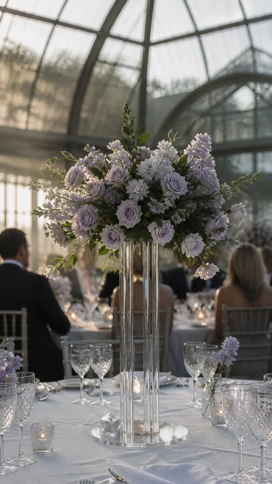 Clear flower stand for weddings Acrylic flower stand with lavender-toned flowers in daylight
